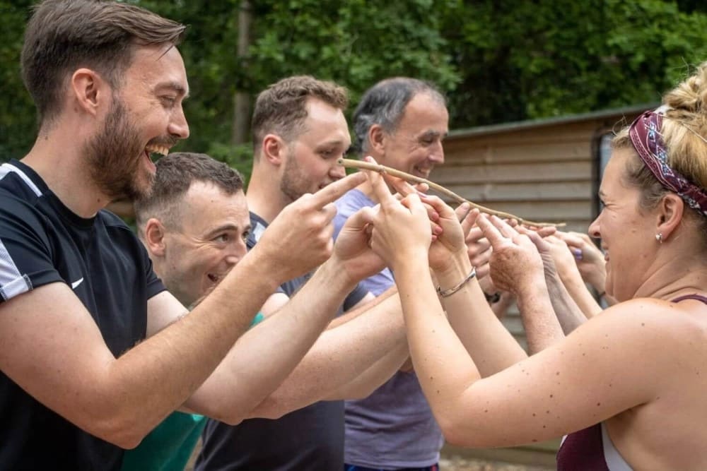 A group of teammates taking part in an outdoor exercise at New Forest Activities as part of a Team Building Day